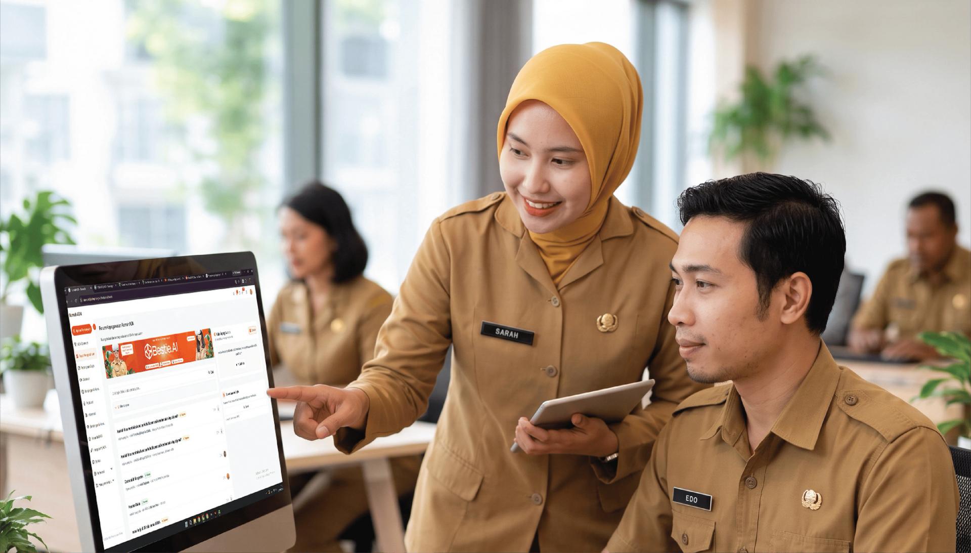 Dua ASN berdiskusi di depan layar Rumah ASN